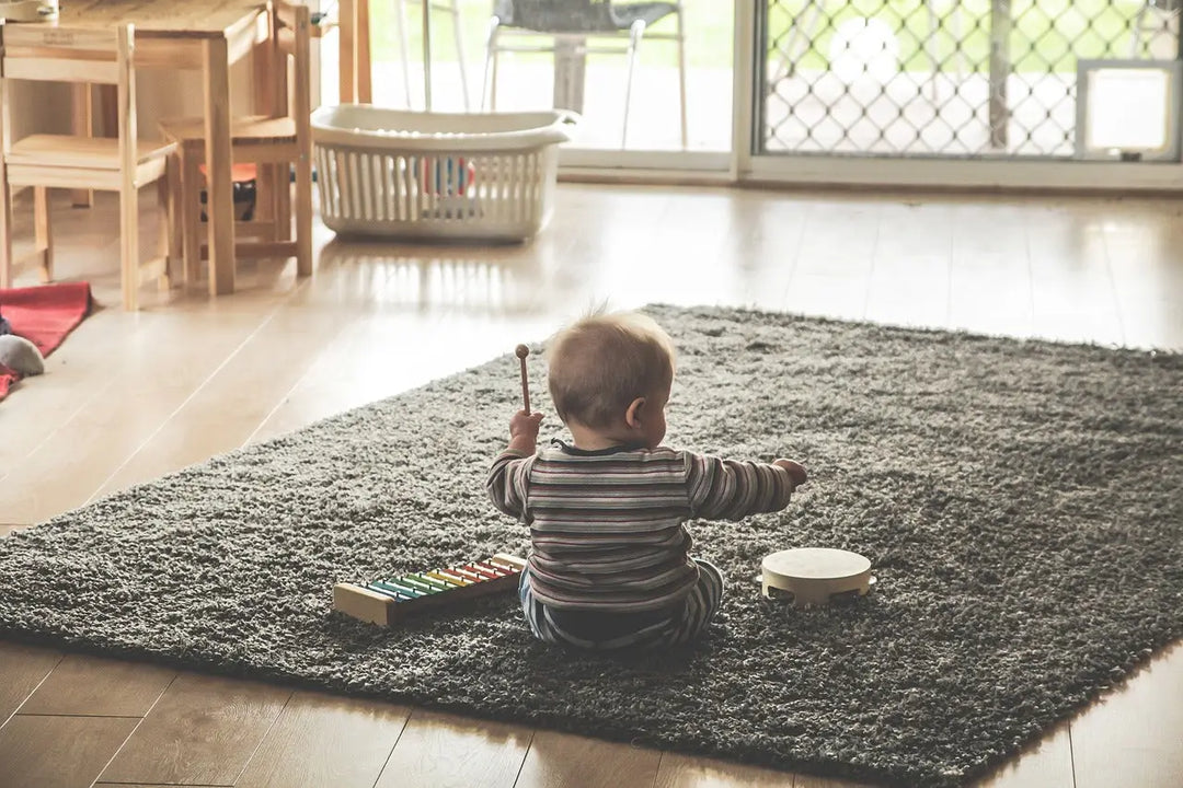 Baby spielt auf einem Teppich